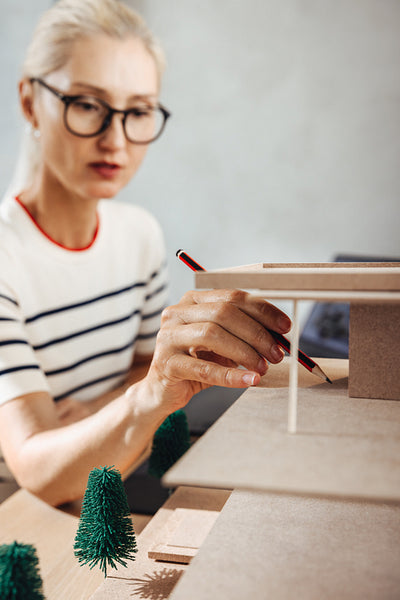 Female architect designing a miniature architectural model for a project work