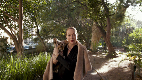 Beautiful wealthy woman at the park with her pet dog