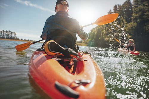 Man in kayak paddling on lake