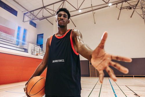 Basketball player reaching out on court