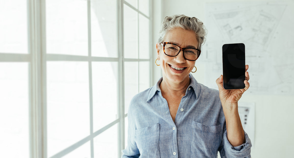 Mobile apps for architects: Happy senior architect holding a mobile ph ...