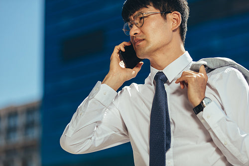 Businessman talking on his mobile phone walking outdoors