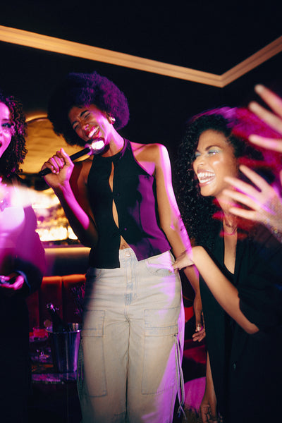 A group of women enjoying karaoke in a vibrant night club setting