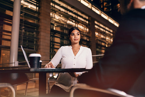Businesswoman sitting at cafe in airport table with businessman