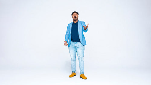 Man wearing coat and cap standing against white background