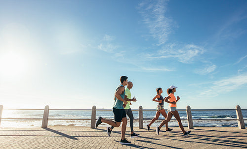 Group running along a seaside promenade