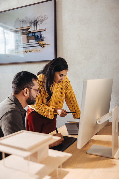 Young architects discussing design ideas at a modern architecture firm workspace