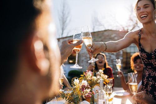 Woman toasting champagne with friend at party