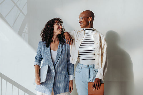 Young businesswomen smiling together in modern office
