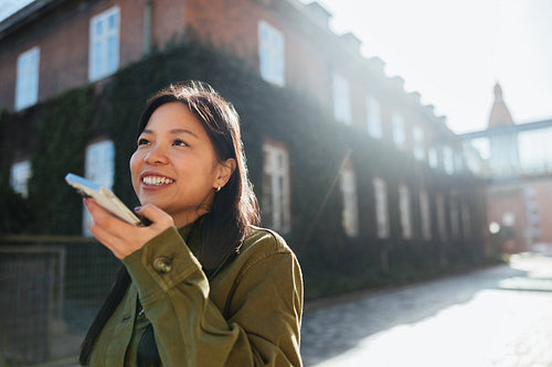 Woman walking and using phone to send voice message