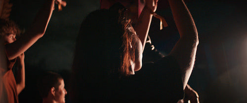 Young woman dances with crowd at a music festival.