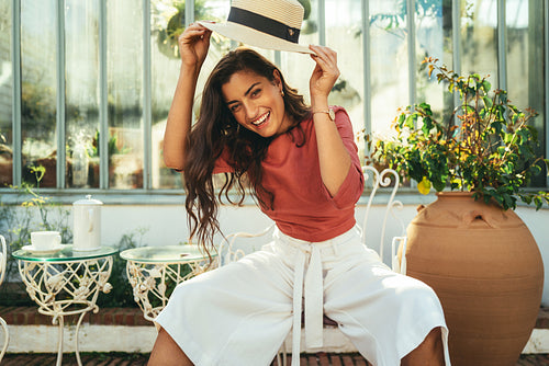Young tourist woman holding up a summer hat
