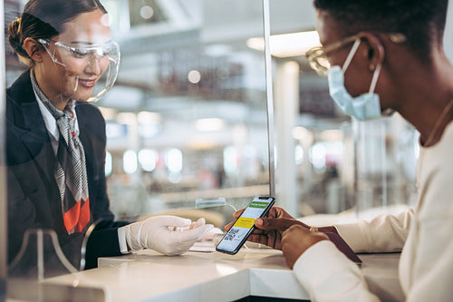 Airport staff checking vaccine passport of passenger