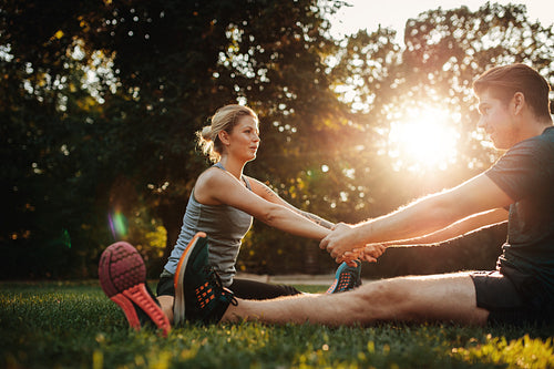 Healthy young man and woman exercising together