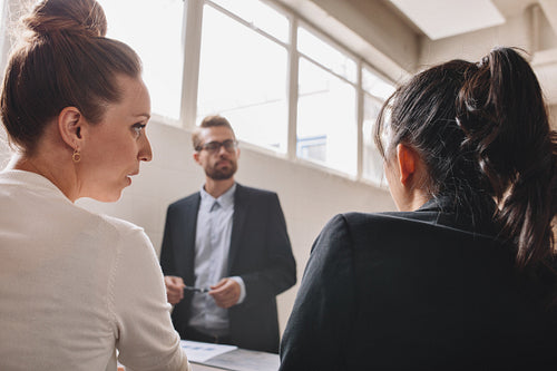 Two young woman discussing during in a meeting