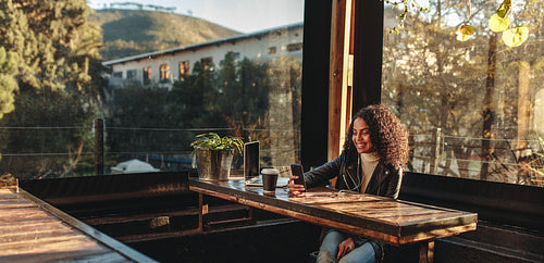 Woman sitting in a coffee shop looking at mobile phone