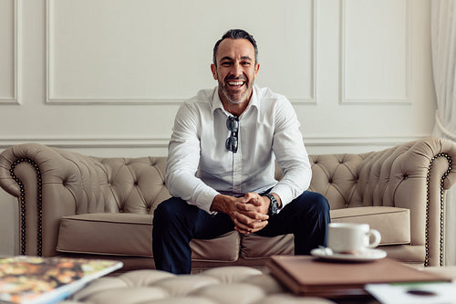 Businessman sitting on couch of hotel room