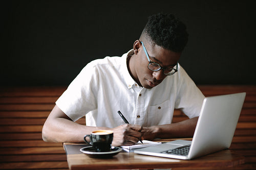 Freelancer working on laptop computer at coffee shop