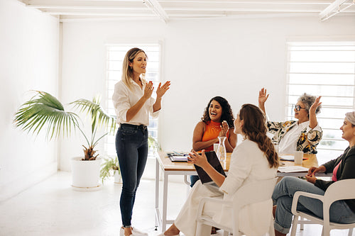 Successful businesswomen clapping hands during a meeting