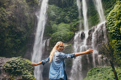 Tourist enjoying by a waterfall in forest