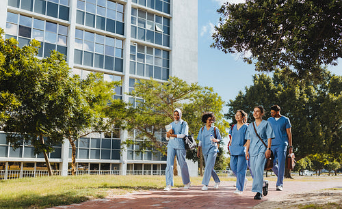 Team of medical students walking along a university hospital campus