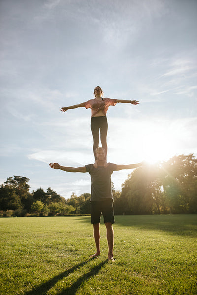 Couple doing acrobatic yoga exercise in park