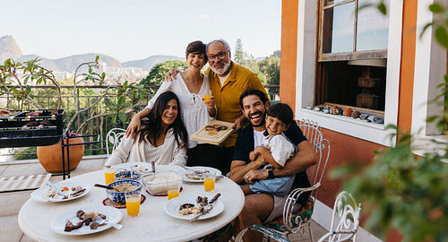 Happy Brazilian family enjoying churrasco on a sunny outdoor patio