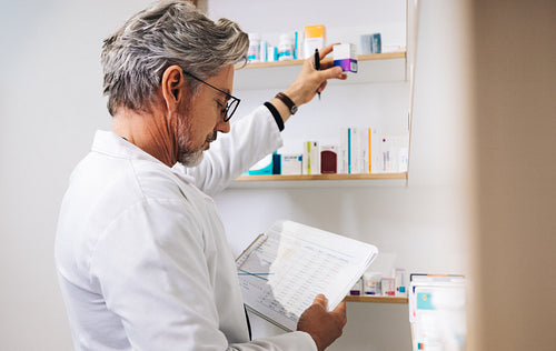 Male pharmacist processing a prescription in a drug store