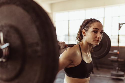Female working out at gym with heavy weights