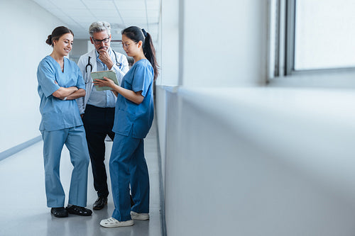 Medical team in action at a teaching hospital: Female interns discuss with a senior doctor