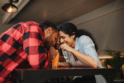 Loving couple having juice from same glass