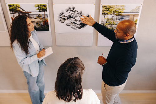 Team collaboration meeting analyzing building plans and architectural designs