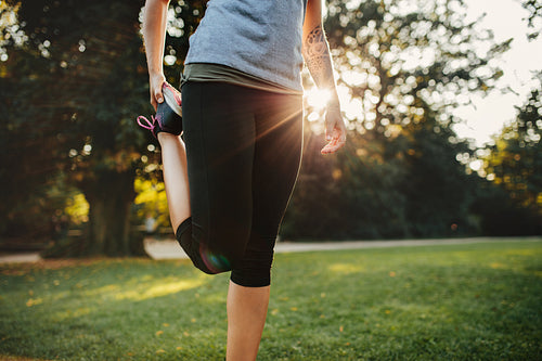 Fitness woman stretching legs in park