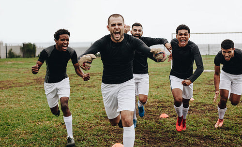Soccer players screaming in joy after victory