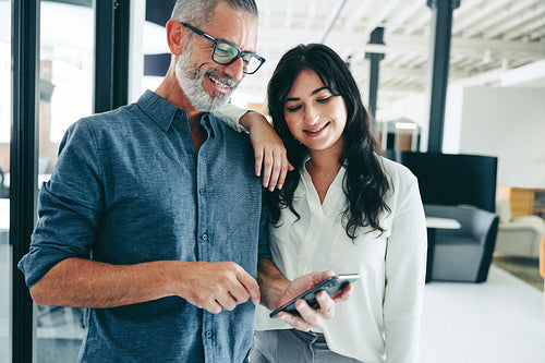 Modern businesspeople using a smartphone together