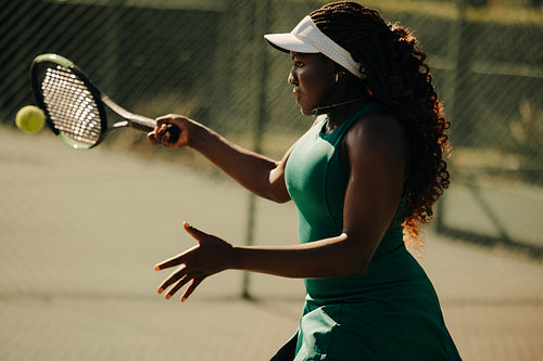 Woman tennis player hitting a forehand stroke on an outdoor court
