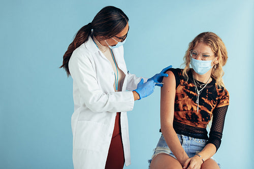 Doctor giving vaccine to woman during pandemic