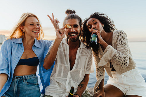 Friends enjoying playful sunset moments by the water