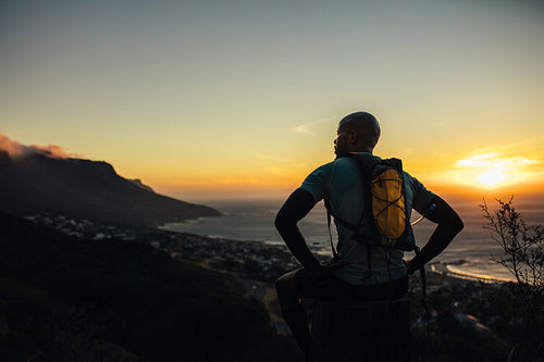 Runner relaxing on trail path on a mountain