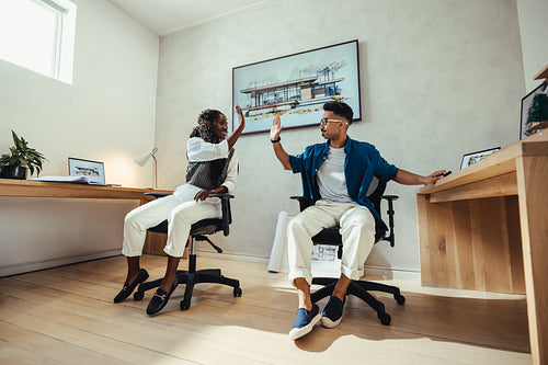 Young architects celebrate a successful project with a high-five