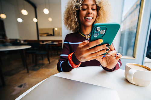 Woman using smartphone in a bright cafe