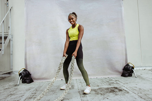 Female doing cross training with battle rope 