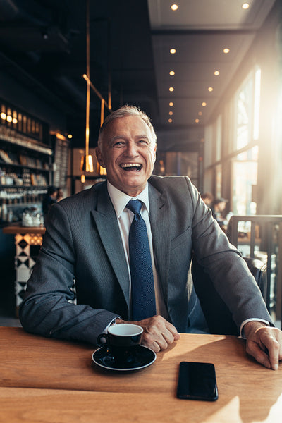Senior businessman laughing at coffee shop