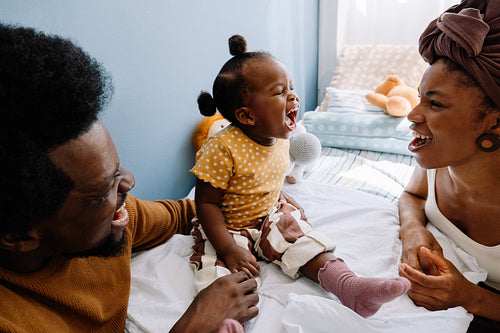 Family laughter with baby and parents at home