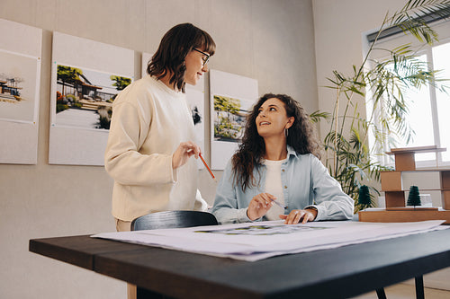 Two female colleagues collaborating on a project in a modern workspace