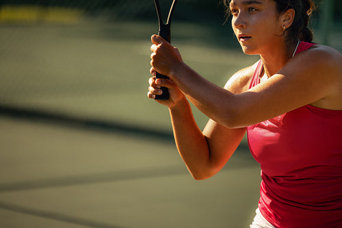 Focused woman playing tennis during a sunny match on an outdoor court