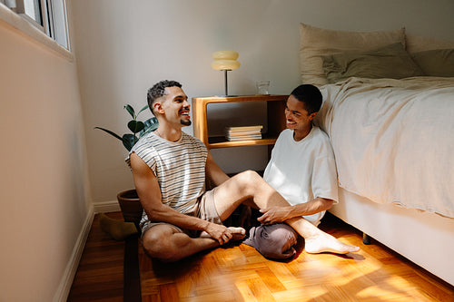 Two men sharing a cheerful moment together on the floor in their room