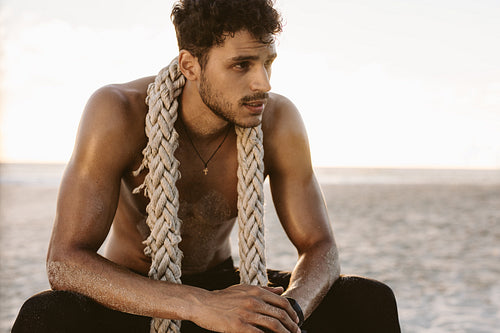 Man relaxing at the beach after workout