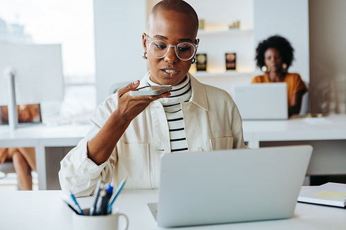 Young businesswoman speaking on smartphone at modern office workplace
