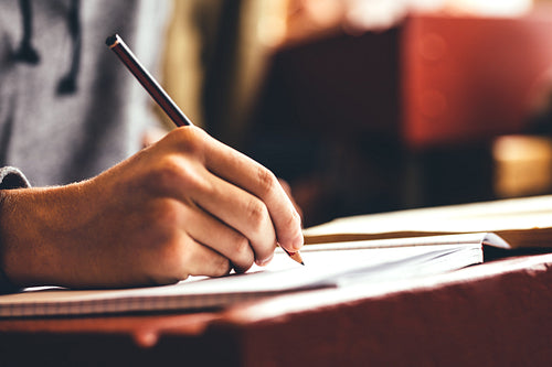 Student in classroom writing in a notebook